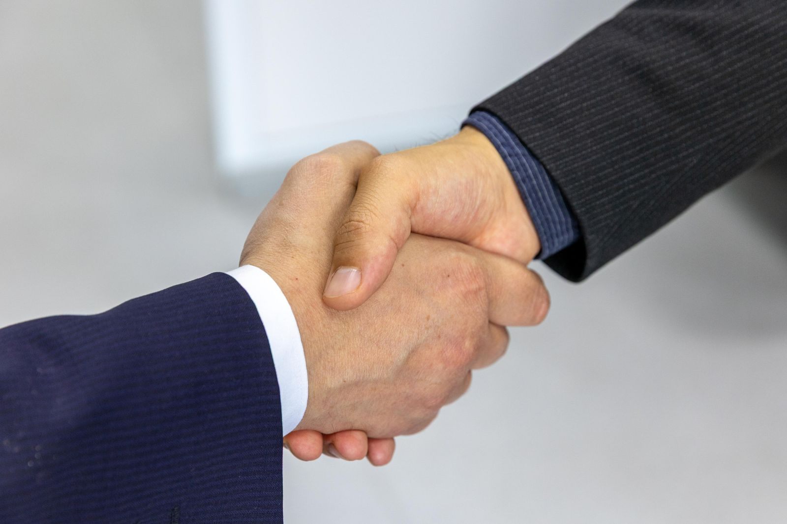 A close-up handshake between two people in business suits after a meeting